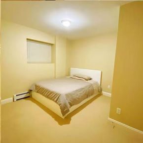 Surrey apartment for rent - A bedroom with a bed, window, and light on the ceiling.