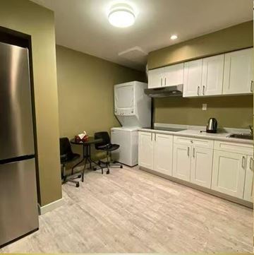 Surrey apartment for rent - A kitchen with a table and chairs and a refrigerator.