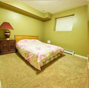 Surrey apartment for rent - A bedroom with a bed, lamp, and carpet.