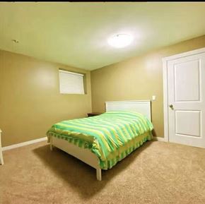 Surrey apartment for rent - A bedroom with a bed and a carpeted floor.