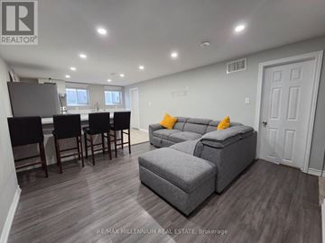 Toronto (L'amoreaux) apartment for rent - A well-lit living room with a grey sofa and a dining table with chairs.