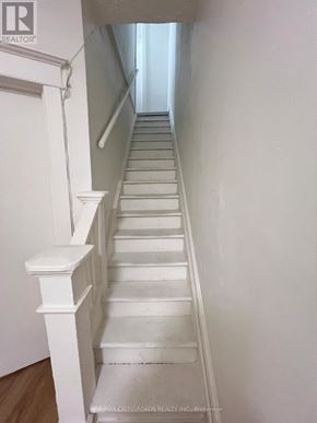 Toronto (South Riverdale) apartment for rent - A long white staircase with a wooden floor.