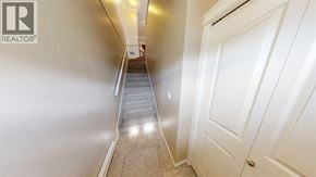 Grande Prairie apartment for rent - A hallway with a staircase leading to a door.