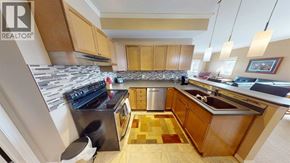 Grande Prairie apartment for rent - A kitchen with wooden cabinets and a black stove top oven.
