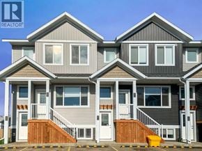 Clairmont apartment for rent - A large, modern house with a grey and brown exterior and a white door.