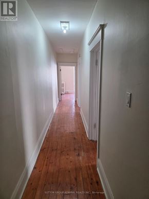 Toronto (Yonge-St. Clair) fourplex for rent - A long hallway with wood floors and white walls.