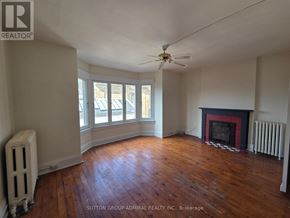 Toronto (Yonge-St. Clair) fourplex for rent - A room with a fireplace and a fan.