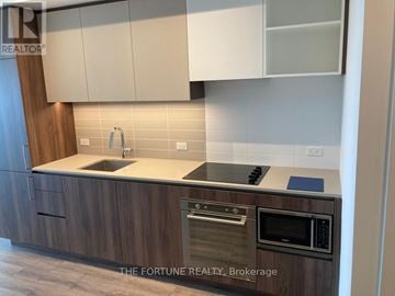 Vaughan (Concord) condo for rent - A kitchen with wooden cabinets and a modern design.