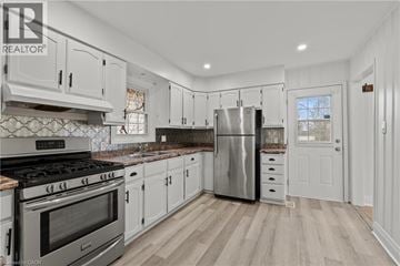 Welland apartment for rent - A modern kitchen with white cabinets and stainless steel appliances.