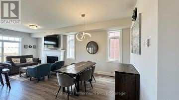 Blue Mountains apartment for rent - A well-lit living room with a fireplace and a dining table set up.