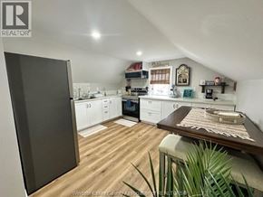 Belle River apartment for rent - A kitchen with wooden floors and white cabinets.