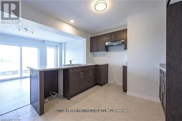 London South (South W) townhouse for rent - A kitchen with dark wood cabinets and a white countertop.