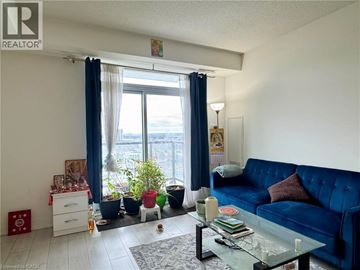 Kitchener condo for rent - A living room with a blue couch and a glass coffee table.