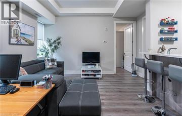 Hamilton condo for rent - A living room with a grey couch and a wooden table.