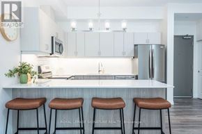 St. Thomas condo for rent - A kitchen with white cabinets and a countertop with three bar stools.