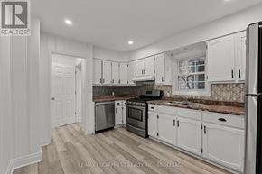 Welland (Prince Charles) multi-family for rent - A kitchen with white cabinets and a refrigerator.