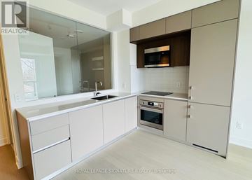 Toronto (Annex) condo for rent - A modern kitchen with white cabinets and stainless steel appliances.