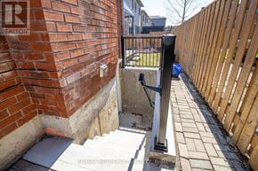 Pickering (Amberlea) apartment for rent - A brick wall with a metal railing and steps leading down to a concrete area.