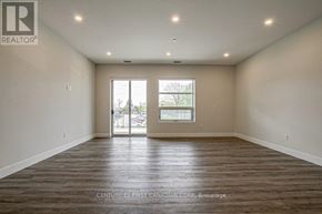 London North (North R) condo for rent - A spacious room with wooden flooring and a large window.
