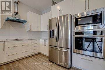 London North (North R) condo for rent - A kitchen with a stainless steel refrigerator and microwave.