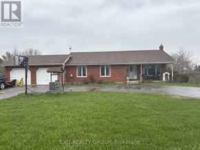 Prince Edward County (Ameliasburg Ward) apartment for rent - A house with a red brick exterior and a white garage door.