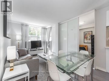 Toronto (Kensington-Chinatown) condo for rent - A modern living room with a glass table and white chairs.