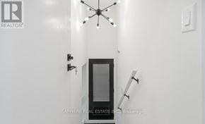 Toronto (Wexford-Maryvale) apartment for rent - A modern interior with a glass door and a chandelier.