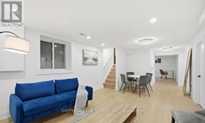 Toronto (Wexford-Maryvale) apartment for rent - A blue couch sits in a well lit room with a dining table and chairs.