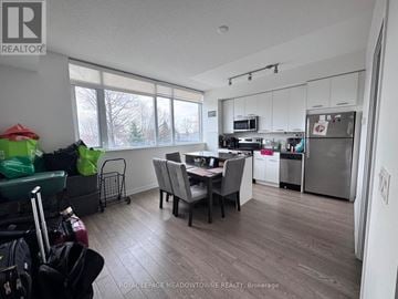 Toronto (Woodbine Corridor) condo for rent - A kitchen with a dining table and chairs in the middle of the room.