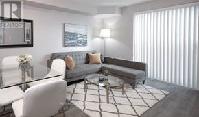 Toronto (Islington-City Centre West) condo for rent - A modern living room with a grey sofa, a glass table, and a white chair.