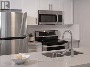 Toronto (Islington-City Centre West) condo for rent - A modern kitchen with a stainless steel refrigerator, microwave, oven, and sink.