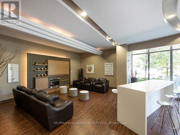 Toronto (Islington-City Centre West) condo for rent - A modern living room with a black leather couch and a white kitchen island.