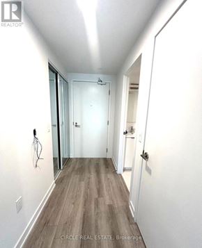 Toronto (Kensington-Chinatown) condo for rent - A hallway with wood flooring and white walls.
