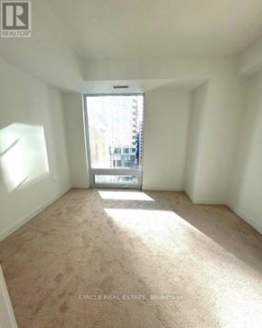 Toronto (Kensington-Chinatown) condo for rent - A carpeted room with a window and a view of a street outside.