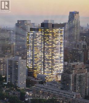 Toronto (Mount Pleasant East) condo for rent - A cityscape with a tall building in the foreground and other buildings in the background.