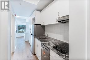 Oshawa (Samac) condo for rent - A kitchen with a black stove top oven and white cabinets.