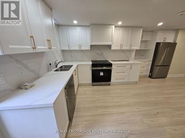 Markham (Buttonville) apartment for rent - A kitchen with white cabinets and a black stove top oven.