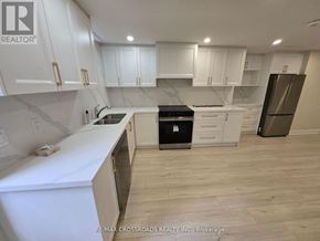 Markham (Buttonville) apartment for rent - A kitchen with white cabinets and a black stove top oven.