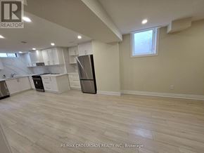 Markham (Buttonville) apartment for rent - A kitchen with white cabinets and a black refrigerator.
