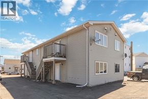 Moncton multi-family for rent - A two-story house with a balcony on the upper floor.