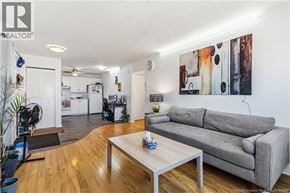 Moncton multi-family for rent - A living room with a grey couch and a coffee table.