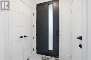 Mississauga (Port Credit) apartment for rent - A black door with a glass panel is in the middle of a white hallway.