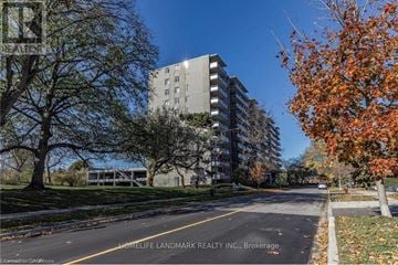 Burlington (Brant) multi-family for rent - A tree with orange leaves is in front of a grey building.