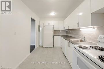 Burlington (Brant) multi-family for rent - A white kitchen with a stove top oven and a sink.