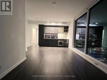 Vaughan (Vaughan Corporate Centre) condo for rent - A spacious kitchen with black cabinets and a large window overlooking the city.
