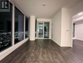 Vaughan (Vaughan Corporate Centre) condo for rent - A room with a view of the city at night through the windows.