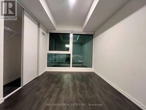 Vaughan (Vaughan Corporate Centre) condo for rent - A room with a sliding glass door and wooden flooring.