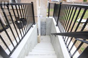 Barrie (Innis-Shore) apartment for rent - A staircase with a black railing and a concrete step.