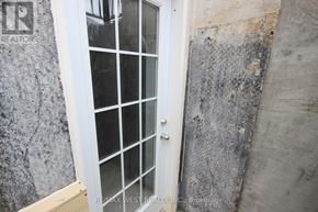 Barrie (Innis-Shore) apartment for rent - A white door with a glass panel is set in a concrete wall.