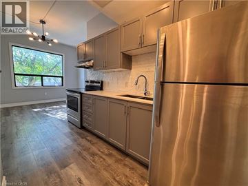 Hamilton apartment for rent - A modern kitchen with a stainless steel refrigerator and wooden flooring.